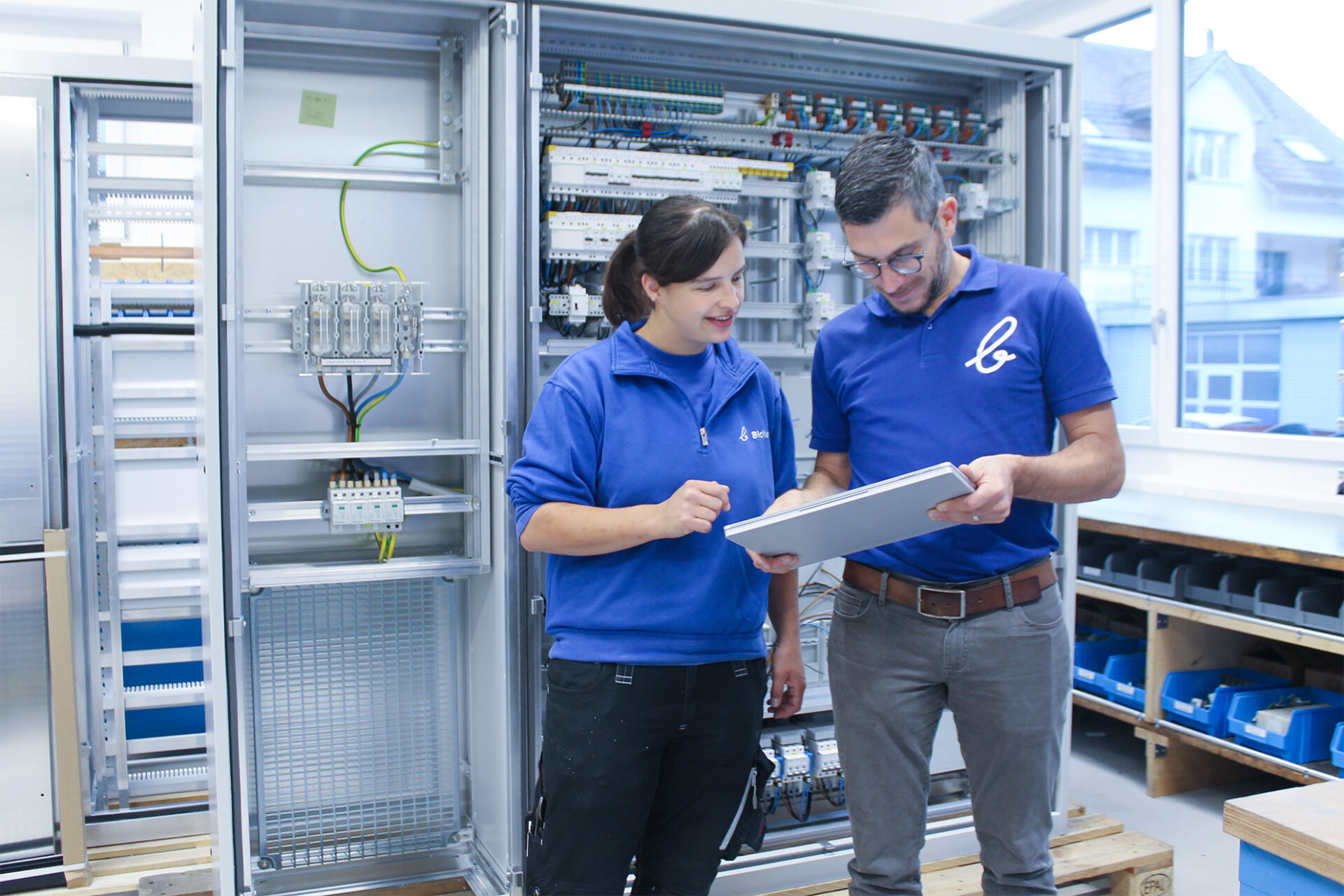 Techniker inspizieren Schaltschrank mit Unterlagen