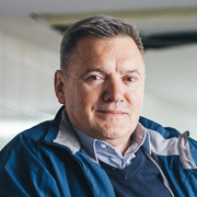 Mann mit blauer Jacke lächelt.